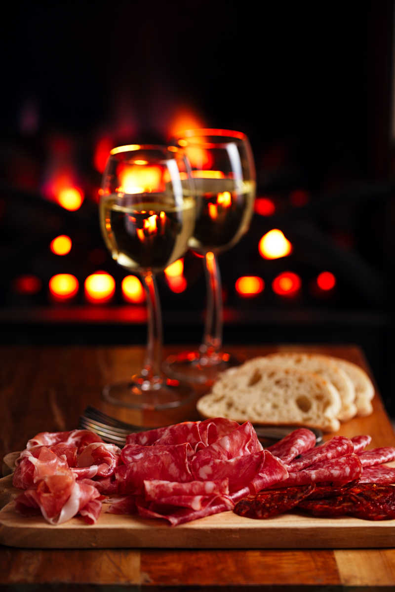 塞拉诺火腿拼盘腊肉与舒适的壁炉和葡萄酒