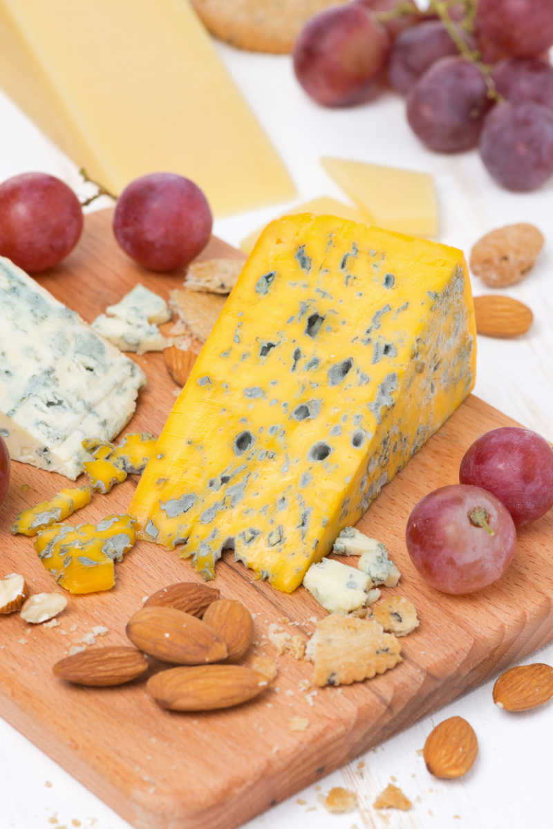 木制砧板上的各种奶酪葡萄和坚果