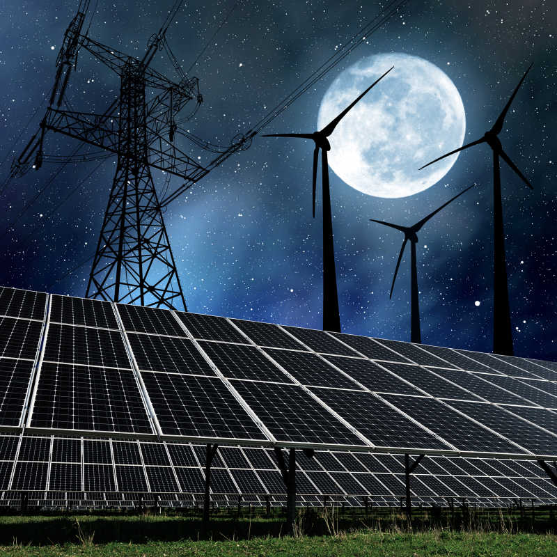 夜空月亮下的太阳能电池板与风力涡轮机和电力塔