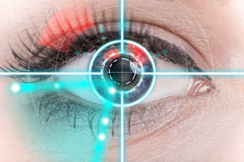 图片展示了一只眼睛的特写，眼睛上方有红色眼影，瞳孔中心出现了类似瞄准镜的图案，周围有蓝色光点。