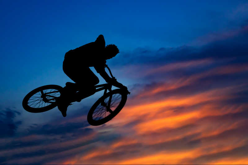 一个骑自行车的人跳跃在美丽的天空中