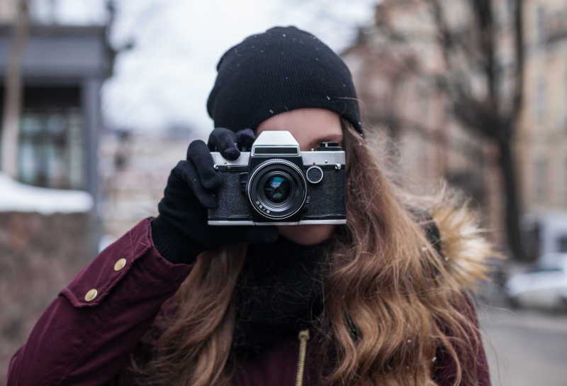 冬天街头的拿着摄像机的女孩