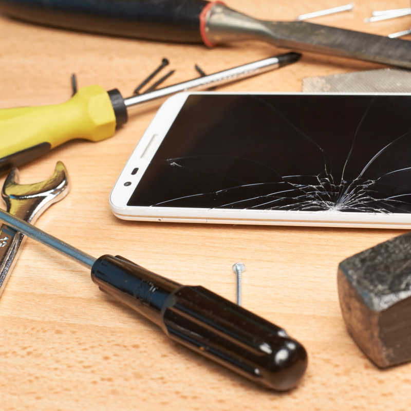 屏幕破碎的智能手机与修理工具