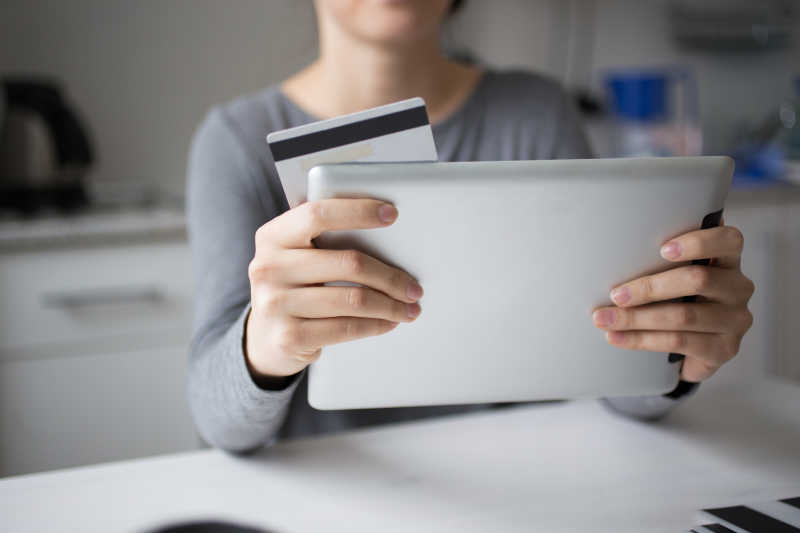 女人拿着平板电脑和信用卡特写