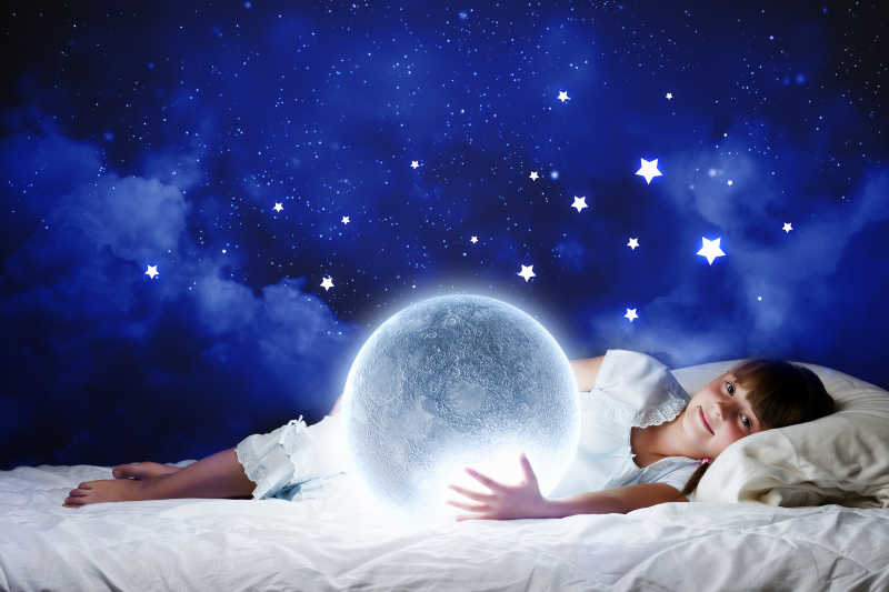 可爱的女孩睡在床上想象月亮与星星