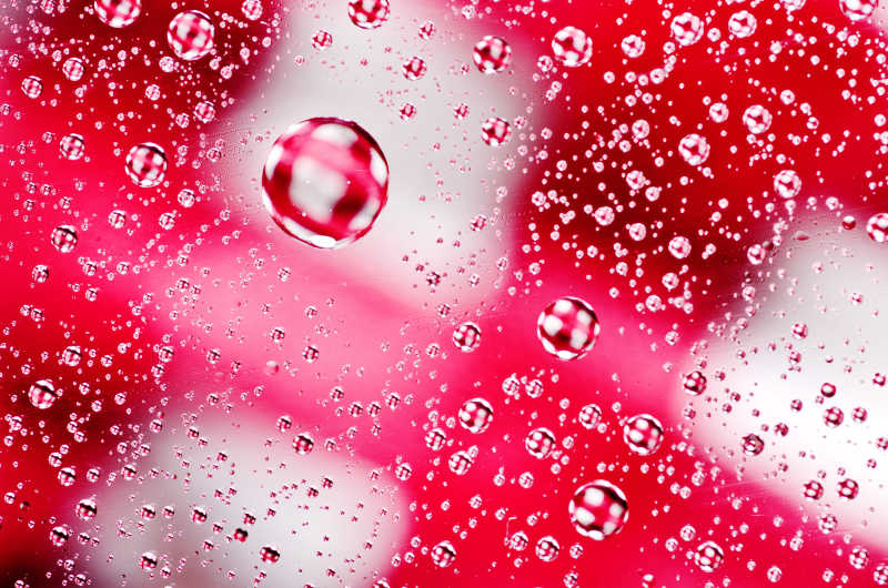 玻璃上的特写水滴在红色的表面上