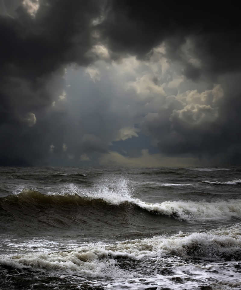 乌云围绕着阳光以及海面上的海浪