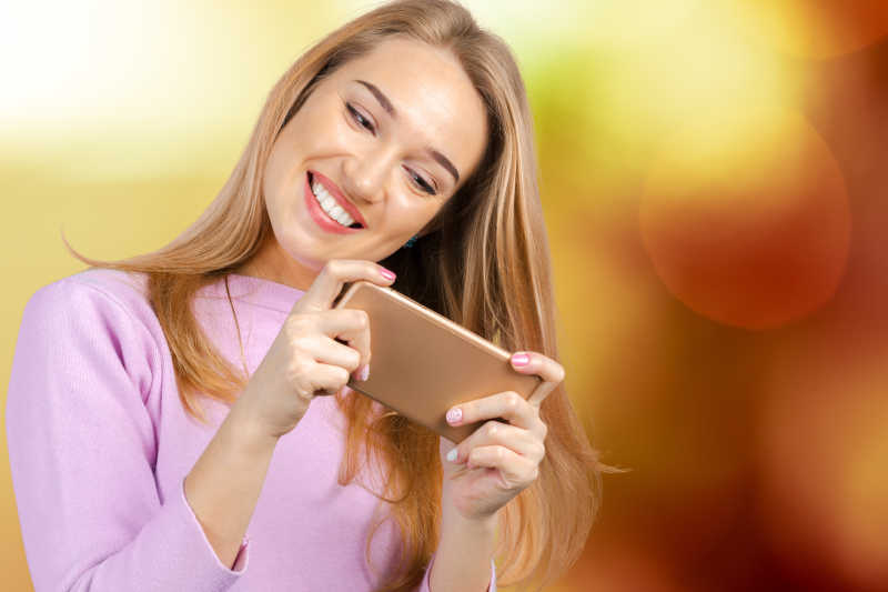 女人微笑的使用智能手机聊天