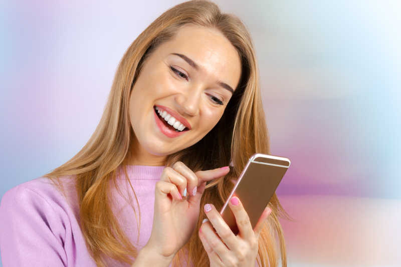 女人微笑的使用智能手机