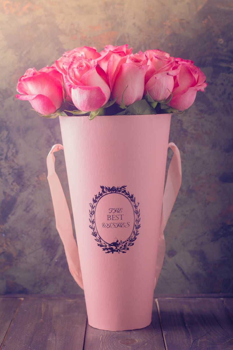 粉红玫瑰所送的情人节或母亲节在木桌背景上
