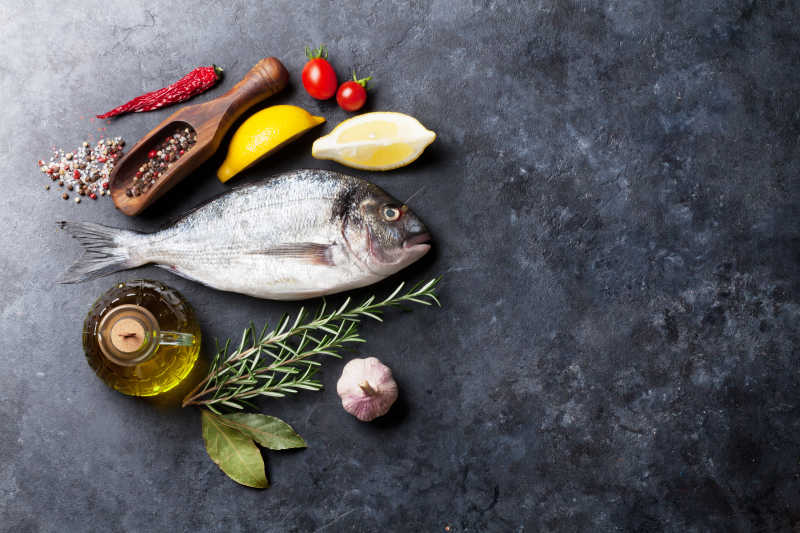 大理石上的鱼以及各种配菜香料