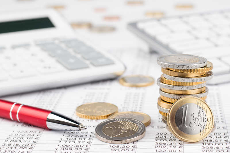 企业财务数据表上的硬币和计算器