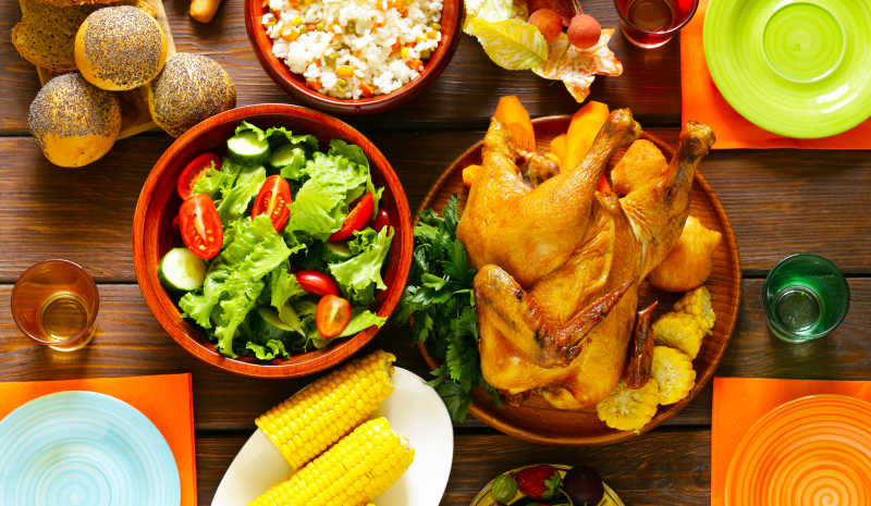 感恩节木桌上的烤鸡玉米和沙拉