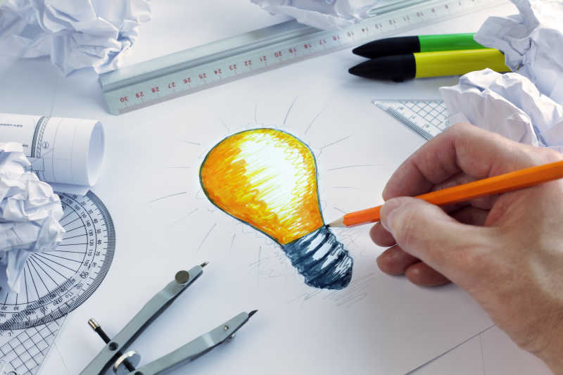 设计师绘制一个灵感爆发的概念灯泡
