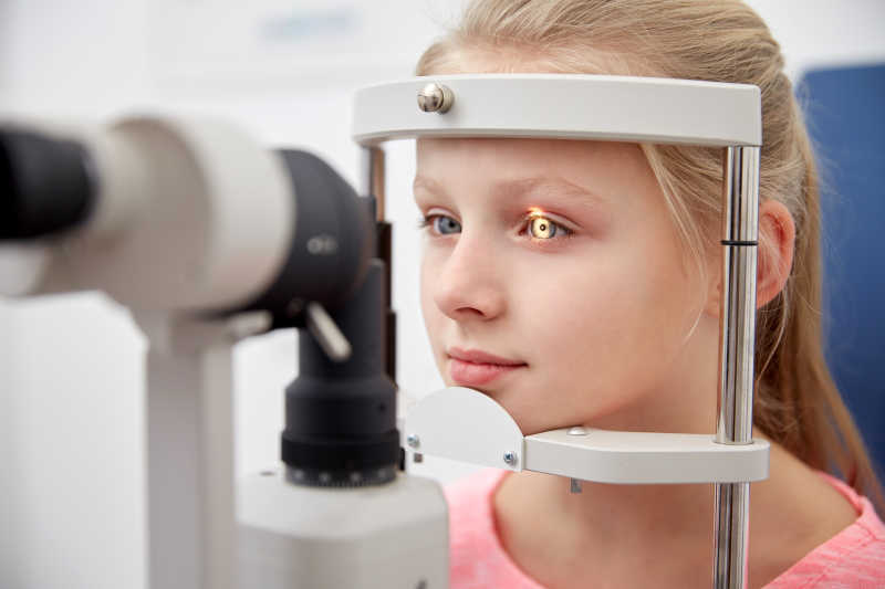 在眼科诊所用眼压计检查视力的女孩