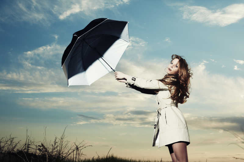 户外一位美丽时尚拿着伞的女性