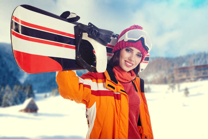 冬季年轻的成年女性拿着滑雪板特写