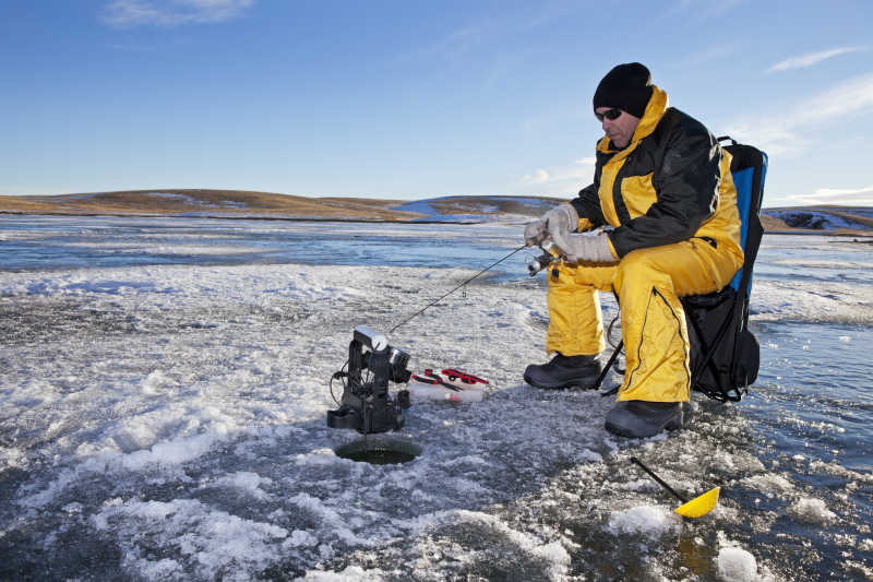 冰湖冰面上的钓鱼爱好者正在钓鱼