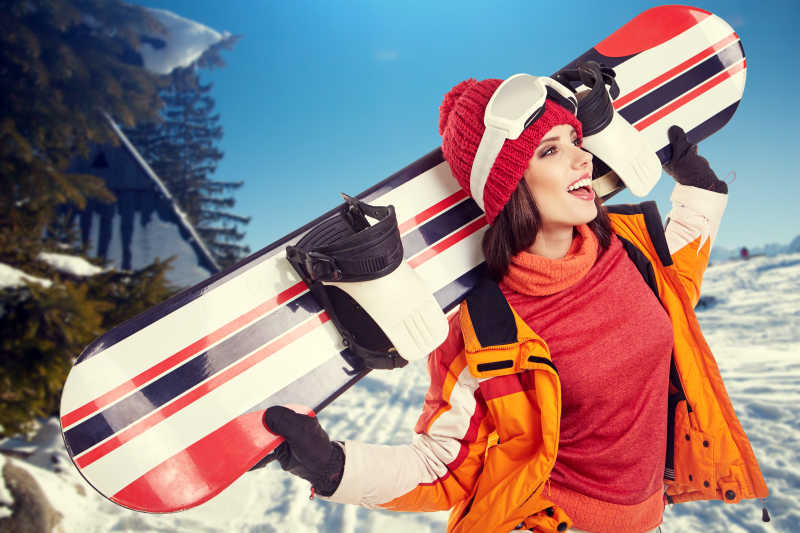 年轻的成年女性拿着滑雪板肖像