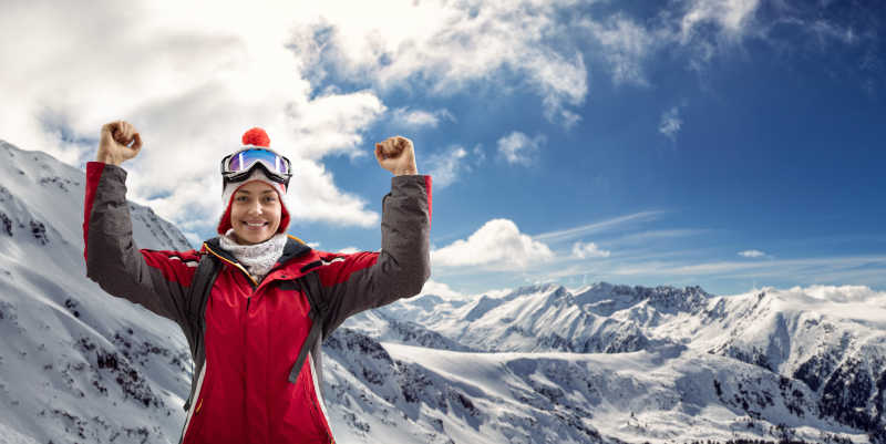 雪山上穿着红色滑雪服的年轻人