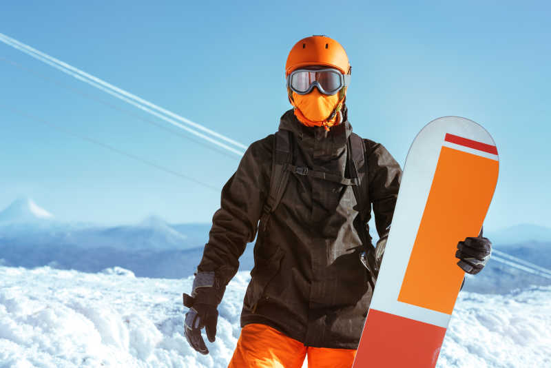 滑雪着拿着滑板在山顶的肖像