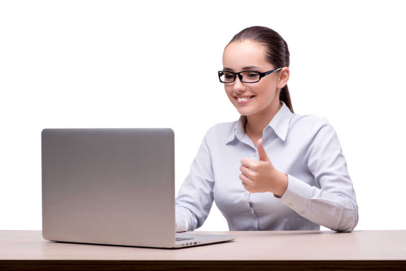 白色背景上的女商人坐在办公室旁边看着电脑微笑的竖起大拇指