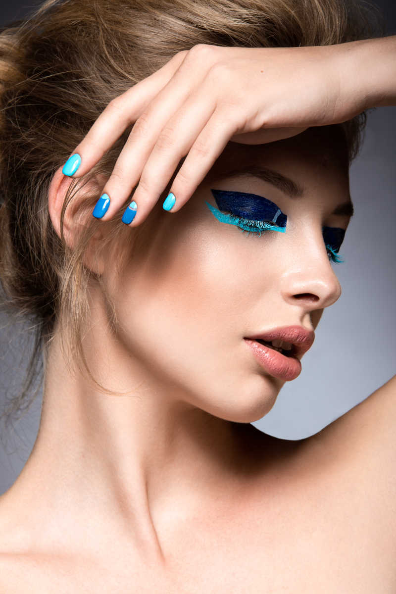 蓝色夸张眼影睫毛膏和美甲的创意彩妆