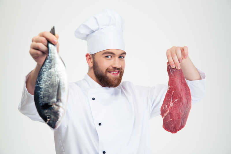 白色背景上的厨师各拿着一条鱼和一条生猪肉