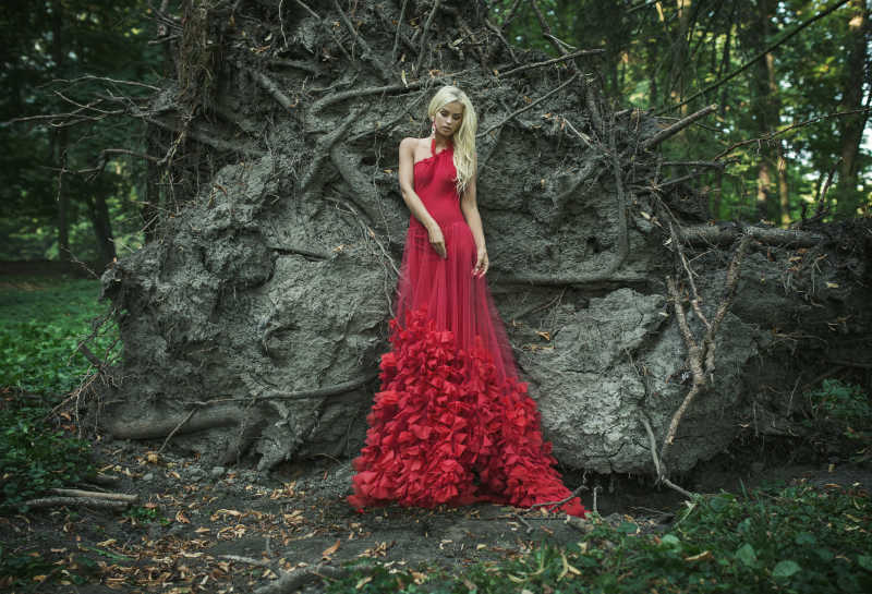 古老的森林里穿着红色纱裙金发美女