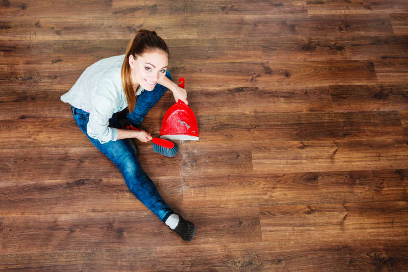 家务清理用红色小笤帚和簸箕扫木地板