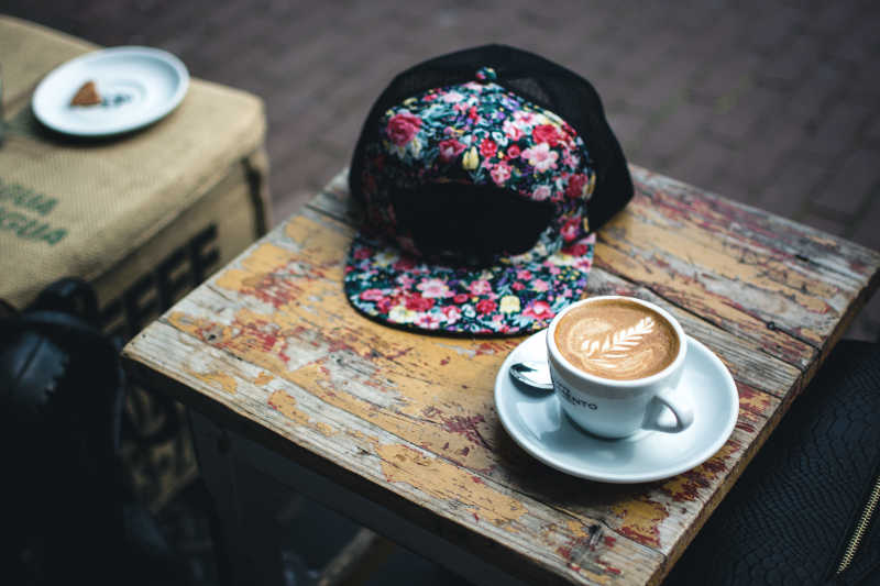 木桌上的咖啡和帽子