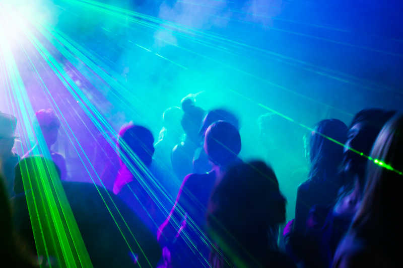 酒吧里的跳舞的人群和绿色激光灯