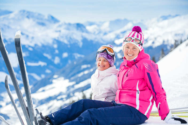 户外雪地上开心滑雪的母女两个人