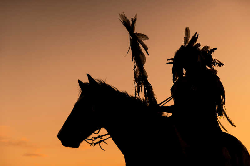 印第安人骑着马和拿着长矛的剪影