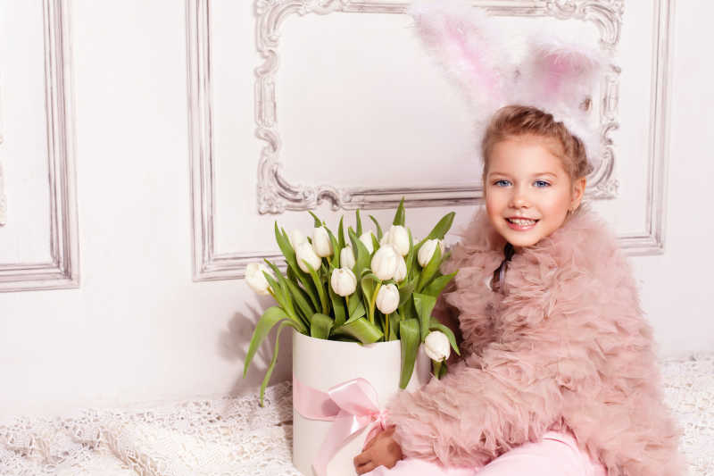 抱着白色郁金香的兔子服装快乐女孩