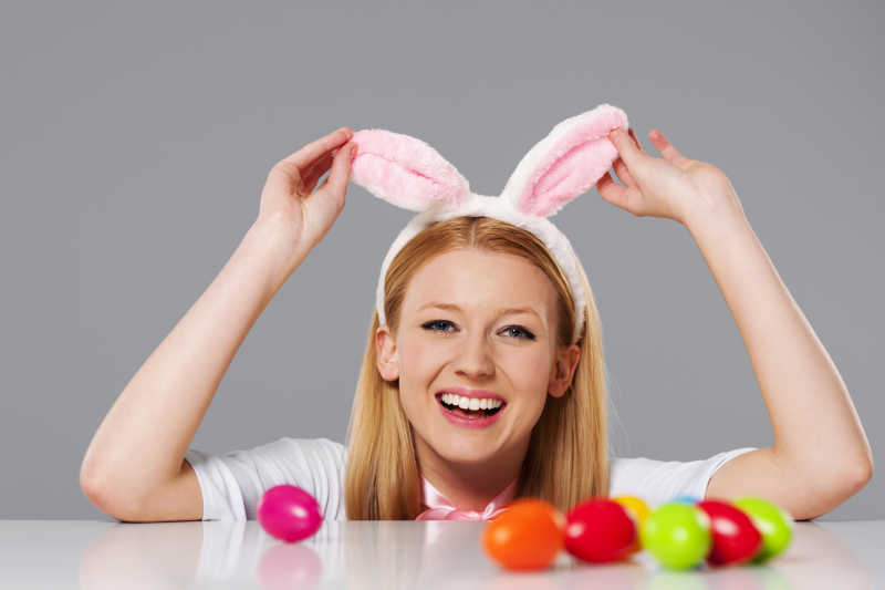 复活节彩蛋和戴着兔耳朵发箍的年轻女子