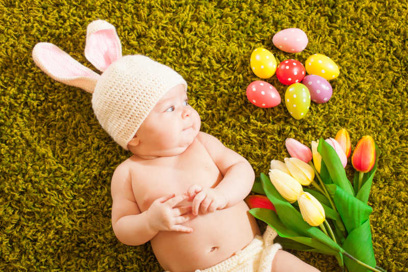 草地上的宝宝和复活节彩蛋郁金香特写