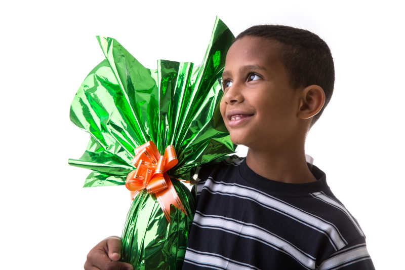 快乐的巴西儿童抱着绿色包装纸的复活节彩蛋