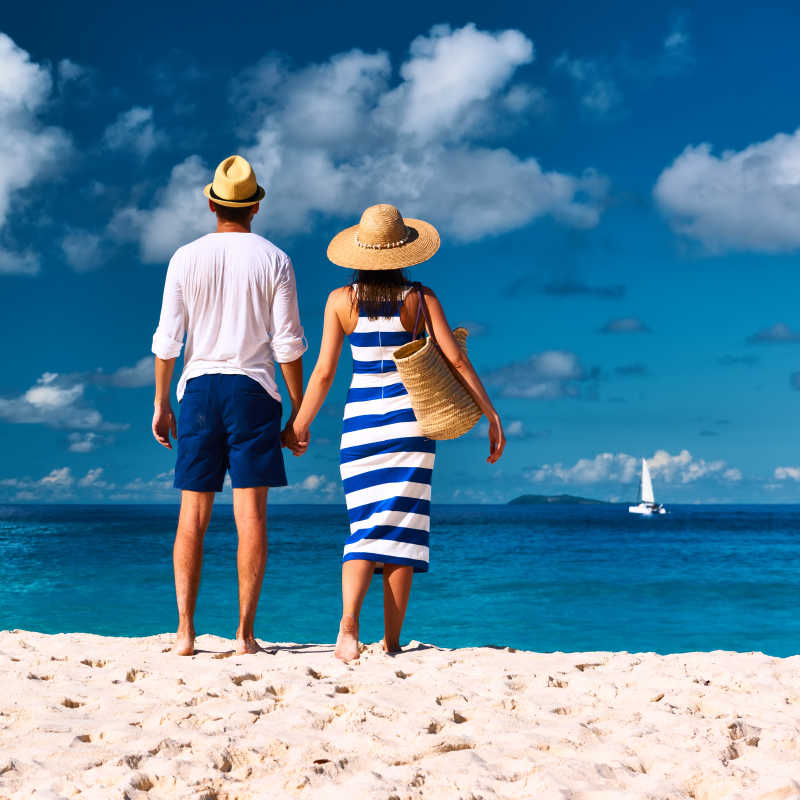 站在塞舌尔海滩上的年轻夫妇