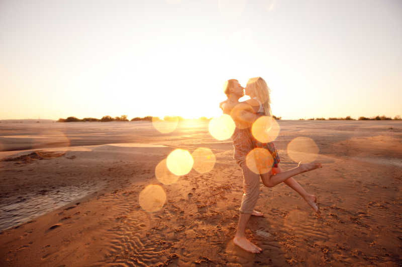 海滩上相拥接吻的快乐情侣