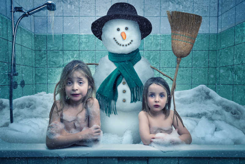 浴缸里的两个满是泡沫的小女孩和雪人特写