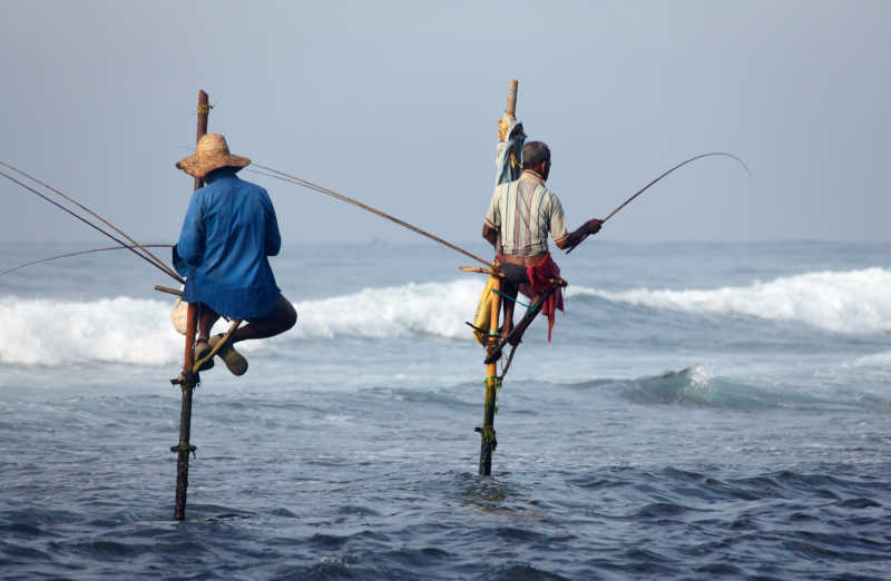 渔夫站在木棍上钓鱼特写