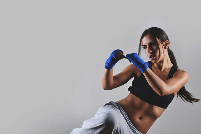 健身女子用蓝色的拳击绷带锻炼