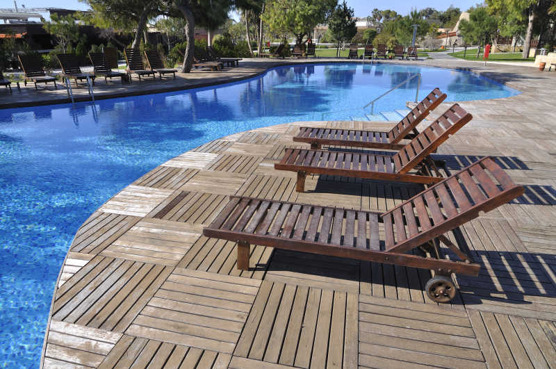 豪华酒店度假村泳池旁的木质躺椅