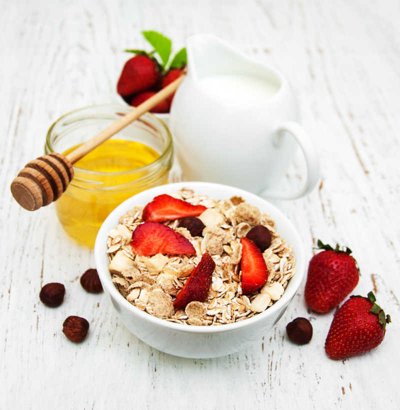 木制背景蜂蜜草莓牛奶麦片营养早餐