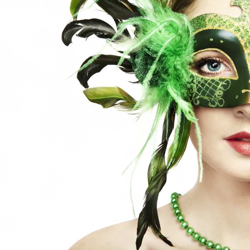 美丽的年轻女子戴着绿色神秘威尼斯面具