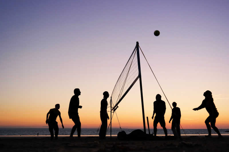 夕阳下玩排球的人群