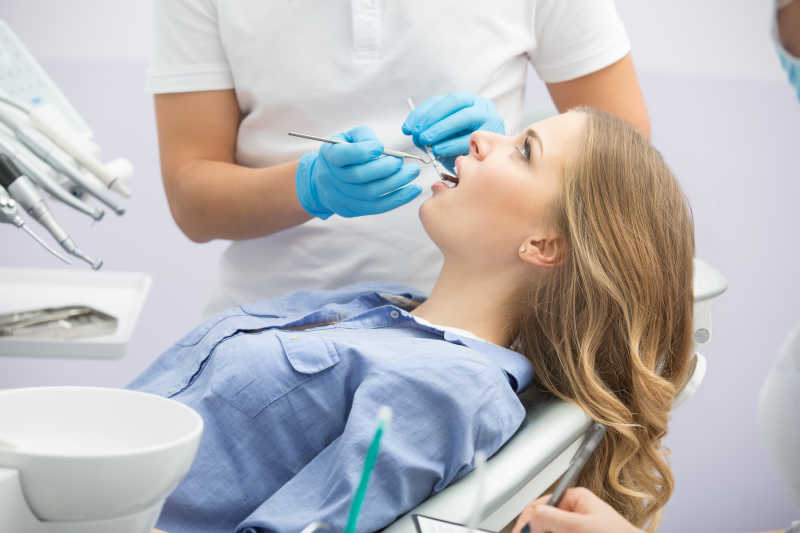 牙科医生帮美女患者检查牙齿特写