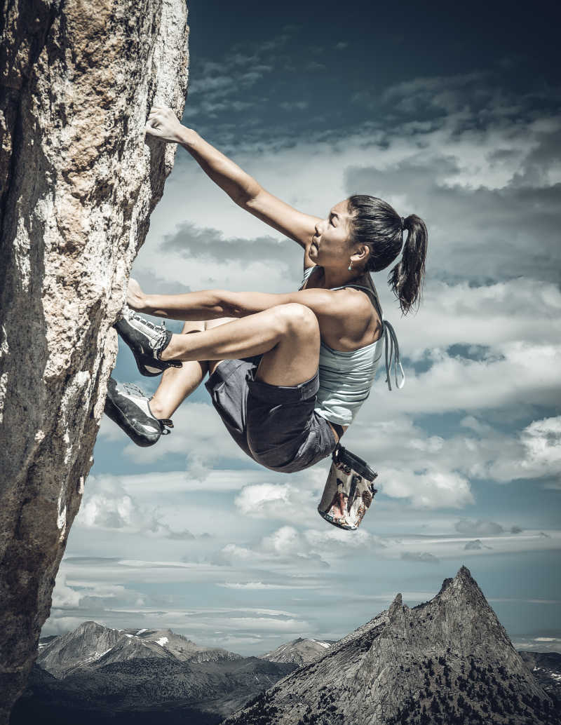 挂在悬崖边上攀岩的女攀岩者