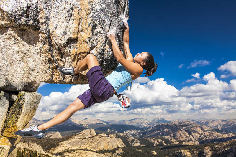 女攀岩者悬挂在悬崖边的一个挑战